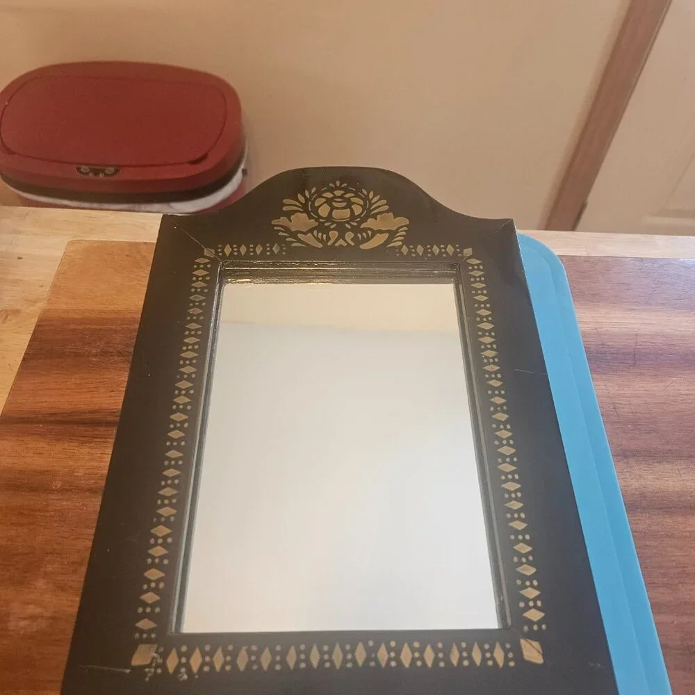 vintage style accent mirror with a black frame with gold stenciling small 8x12